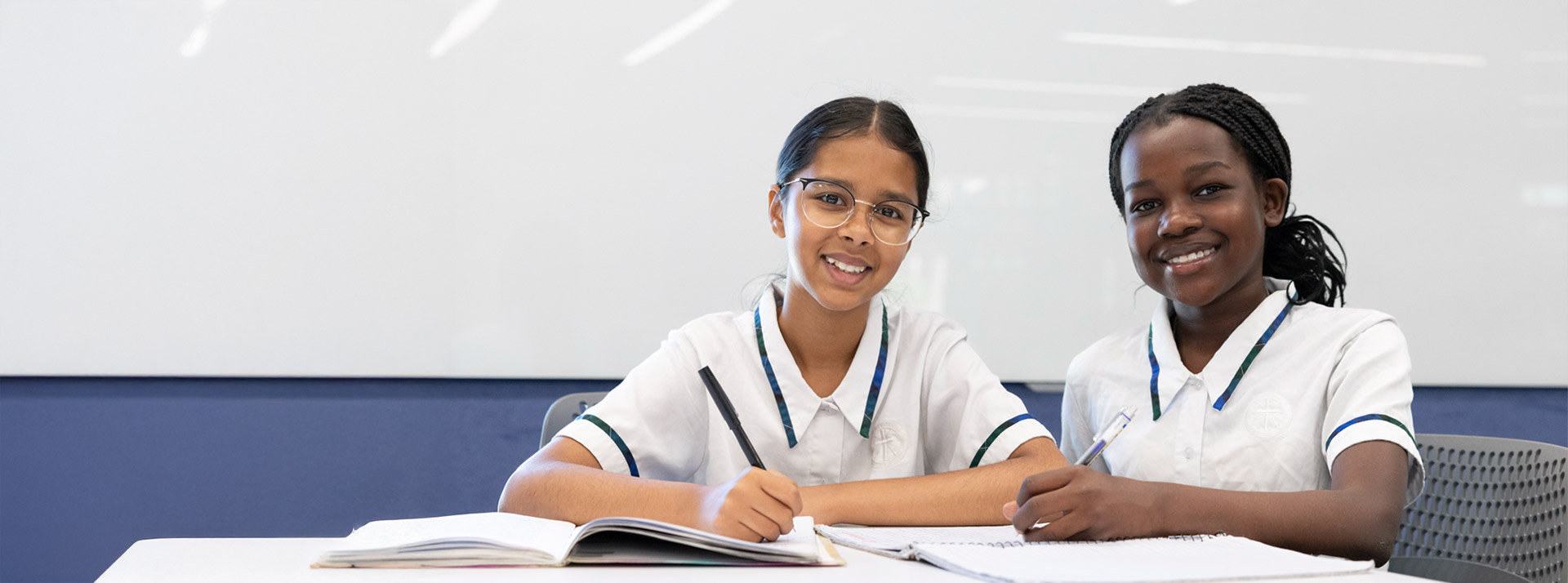 Nagle Catholic College students with workbooks. A whiteboard is in the background.