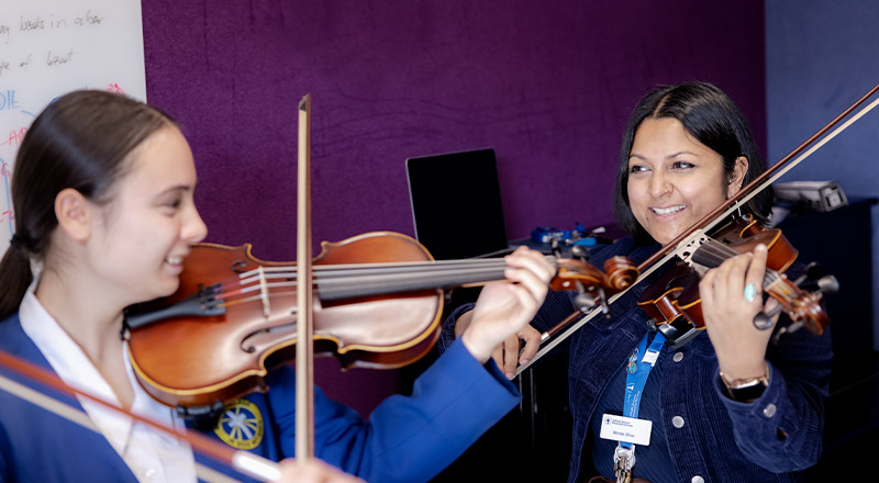 Nagle Catholic College South Blacktown student learning violin from music teacher